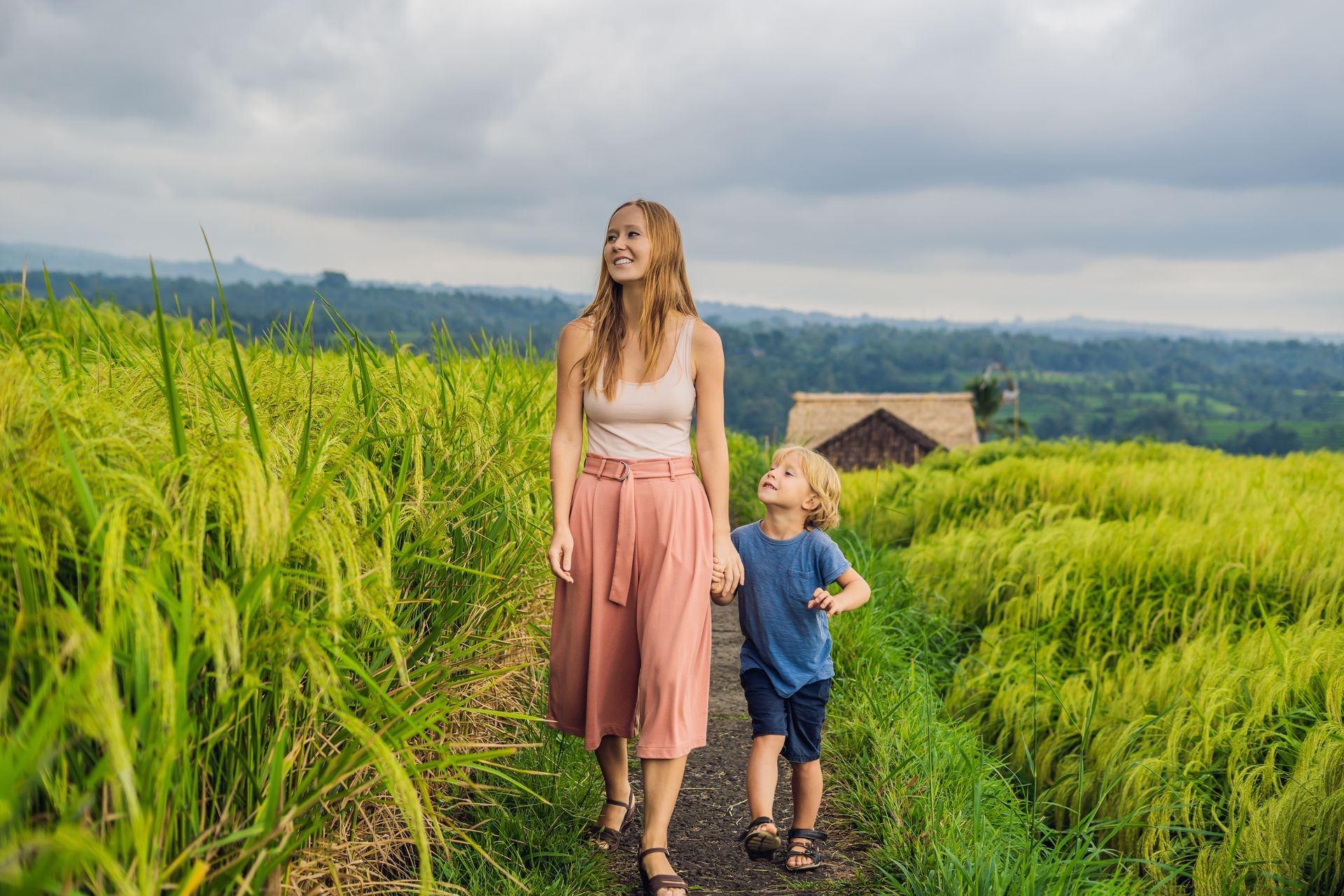 Mom and son travelers on Beautiful Jatiluwih Rice Terraces against the background of famous volcanoes in Bali, Indonesia Traveling with children concept